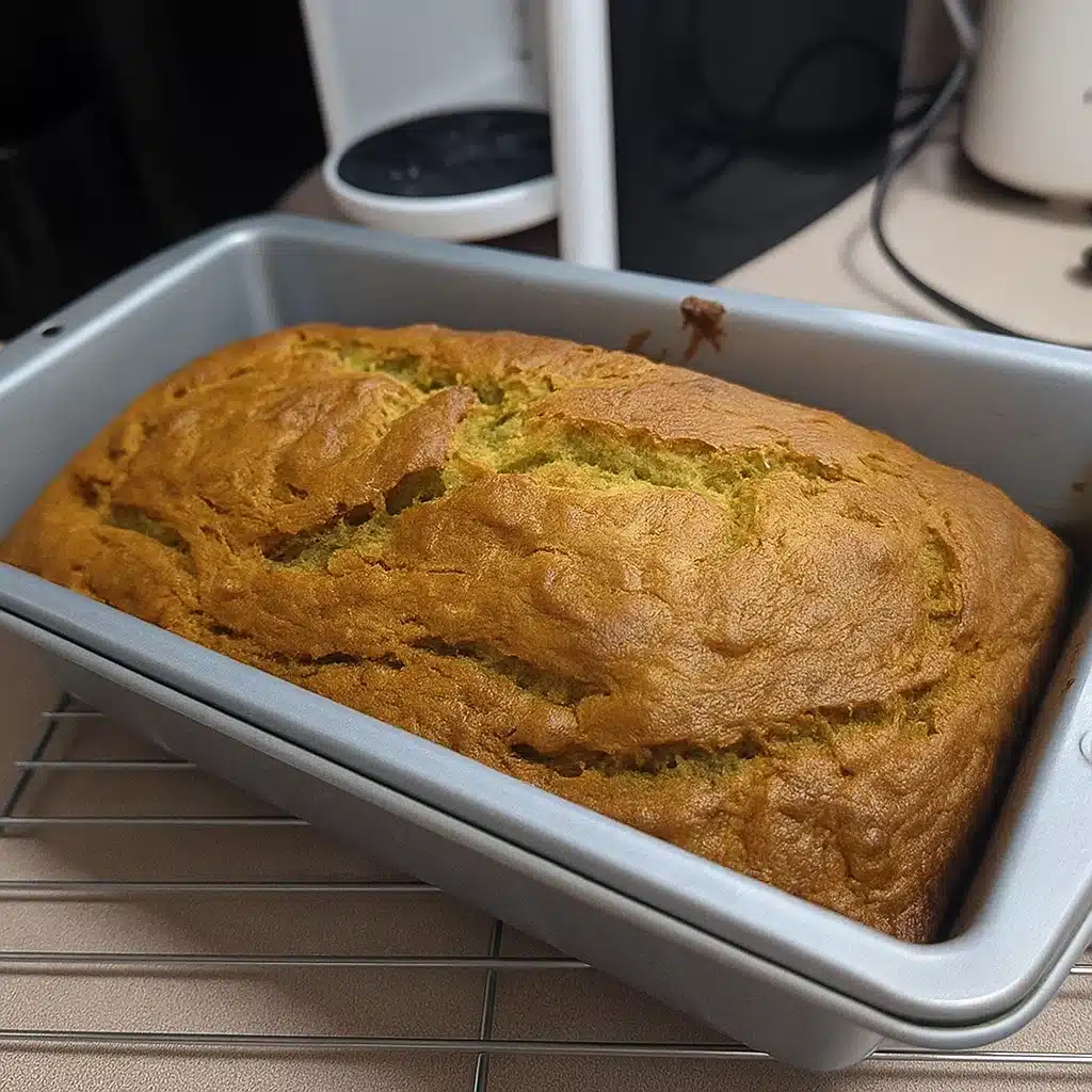 Perfect Banana Bread 6 Golden brown banana bread loaf sliced on a wooden cutting board with fresh bananas and a vintage knife nearby